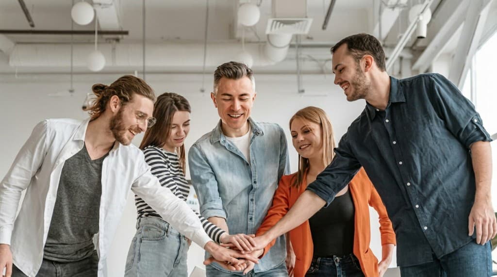 Equipo de trabajo unido con las manos en el centro